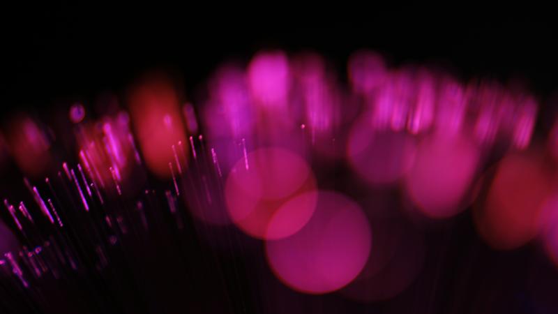 Bokeh lumineux rose et pourpre dans l'obscurité